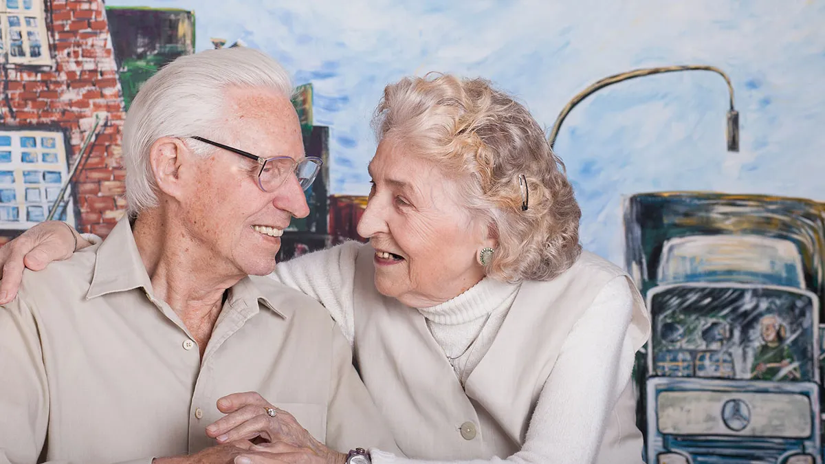 Ehepaar, das im PFLEGEN & WOHNEN HAMBURG in Altona lebt, lächelt sich an.