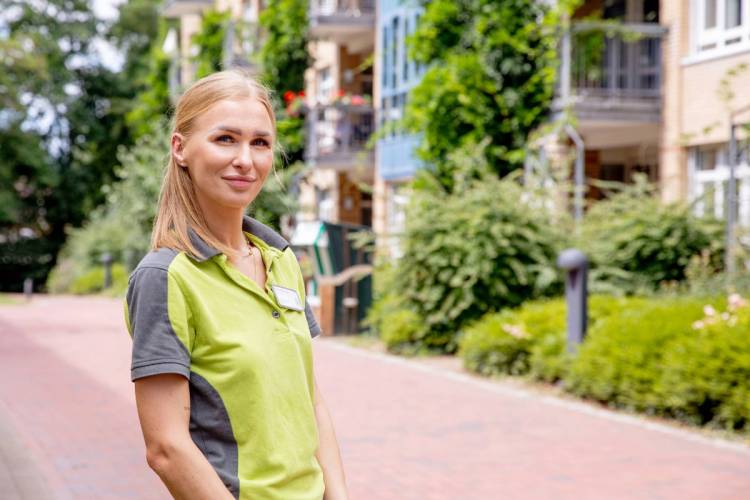 Pflegefachkraft Alicja Centkowska im Außenbereich des Standorts Moosberg bei PFLEGEN & WOHNEN HAMBURG.